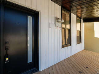 Discover this charming property featuring a modern black front door with a glass panel, offering a stylish entrance.