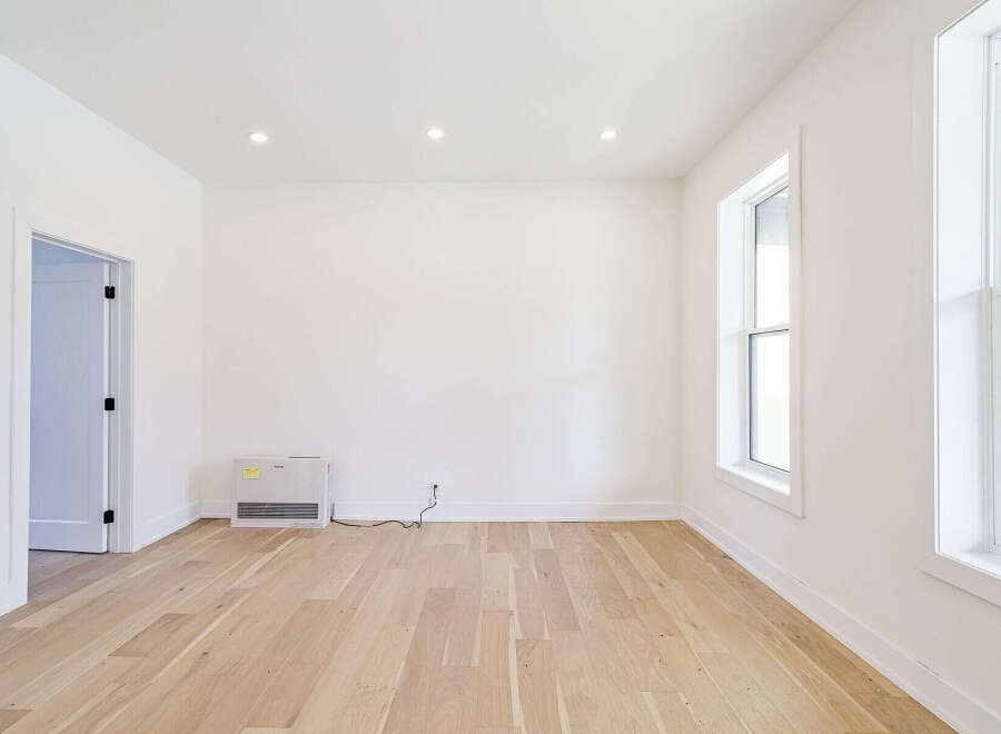 This bright and airy room features beautiful hardwood floors and crisp white walls, creating a clean and inviting atmosphere.