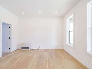 This bright and airy room features beautiful hardwood floors and crisp white walls, creating a clean and inviting atmosphere.