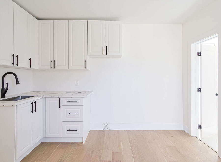 This stunning kitchen boasts modern design with sleek white cabinetry and elegant black hardware.