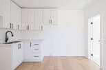 This stunning kitchen boasts modern design with sleek white cabinetry and elegant black hardware.