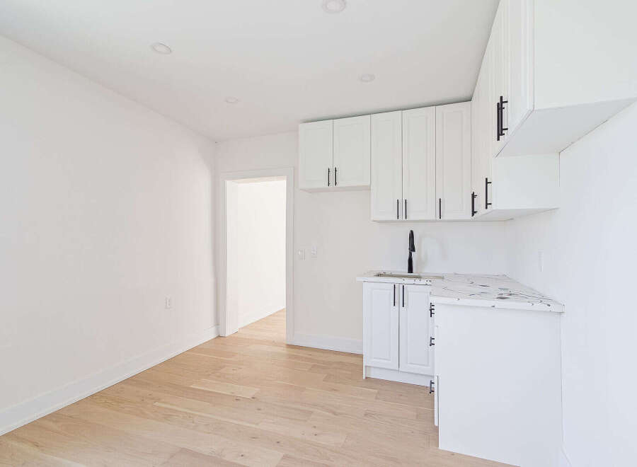 This stunning property boasts a modern kitchen with sleek white cabinetry and a stylish countertop.