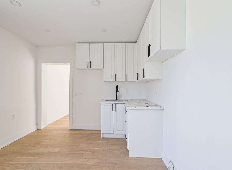 Discover modern living in this stunning property! Featuring a sleek, all-white kitchen with ample cabinet space and a stylish countertop.