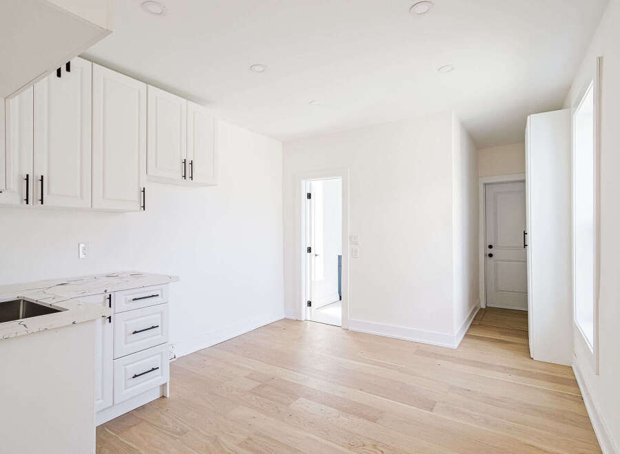 This stunning kitchen boasts modern design with sleek white cabinetry and a beautiful marble countertop.
