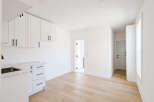 This stunning kitchen boasts modern design with sleek white cabinetry and a beautiful marble countertop.