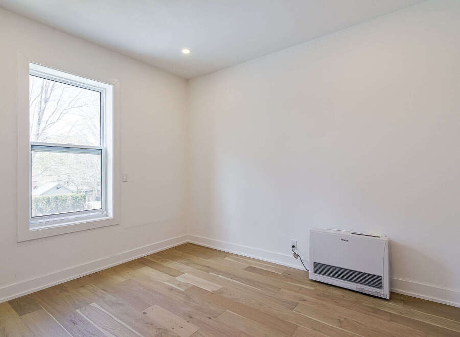 This bright and airy room features beautiful hardwood floors and crisp white walls, creating a clean and inviting atmosphere.