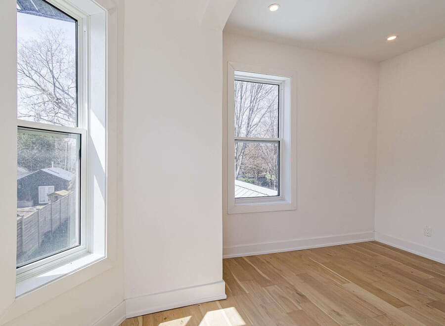 This bright and airy room features beautiful hardwood floors and crisp white walls, creating a clean and modern aesthetic.