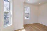 This bright and airy room features beautiful hardwood floors and crisp white walls, creating a clean and modern aesthetic.