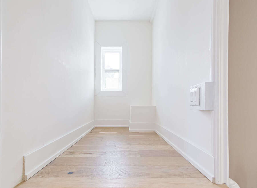 This bright and airy space features pristine white walls and elegant hardwood floors, creating a clean and inviting atmosphere.