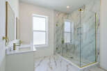 Step into luxury with this stunning bathroom featuring a spacious glass-enclosed shower and elegant marble accents.