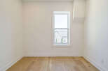 This bright and airy room features beautiful hardwood floors and crisp white walls, creating a clean and inviting atmosphere.