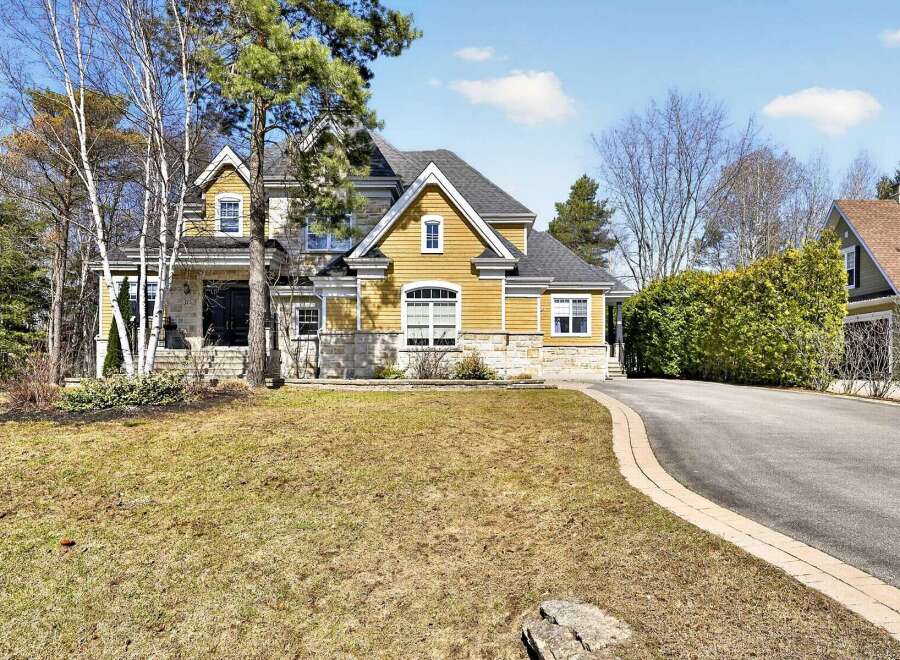 This stunning property boasts a beautiful exterior with a combination of stone and yellow siding, creating a warm and inviting curb appeal.