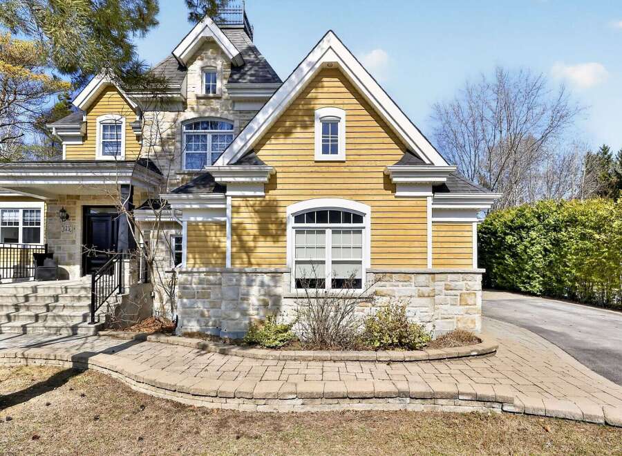 This stunning property boasts a beautiful exterior with a combination of stone and yellow siding, creating a charming curb appeal.