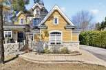 This stunning property boasts a beautiful exterior with a combination of stone and yellow siding, creating a charming curb appeal.