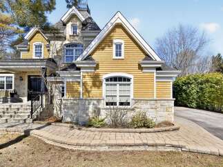 This stunning property boasts a beautiful exterior with a combination of stone and yellow siding, creating a charming curb appeal.