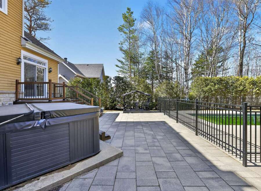 Enjoy luxurious outdoor living with this stunning property featuring a spacious patio and a relaxing hot tub.