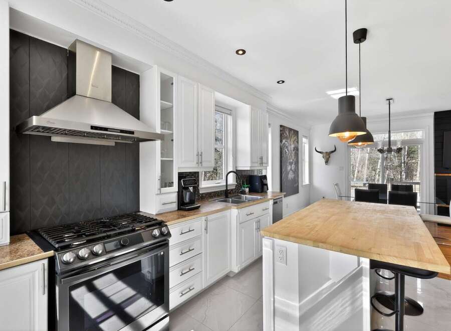Step into this stunning kitchen, featuring sleek stainless steel appliances and a modern design.