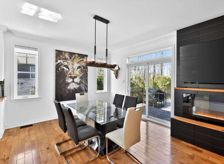 This stunning dining room boasts a modern design with a sleek glass table and stylish chairs, perfect for hosting gatherings.