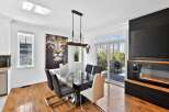 This stunning dining room boasts a modern design with a sleek glass table and stylish chairs, perfect for hosting gatherings.