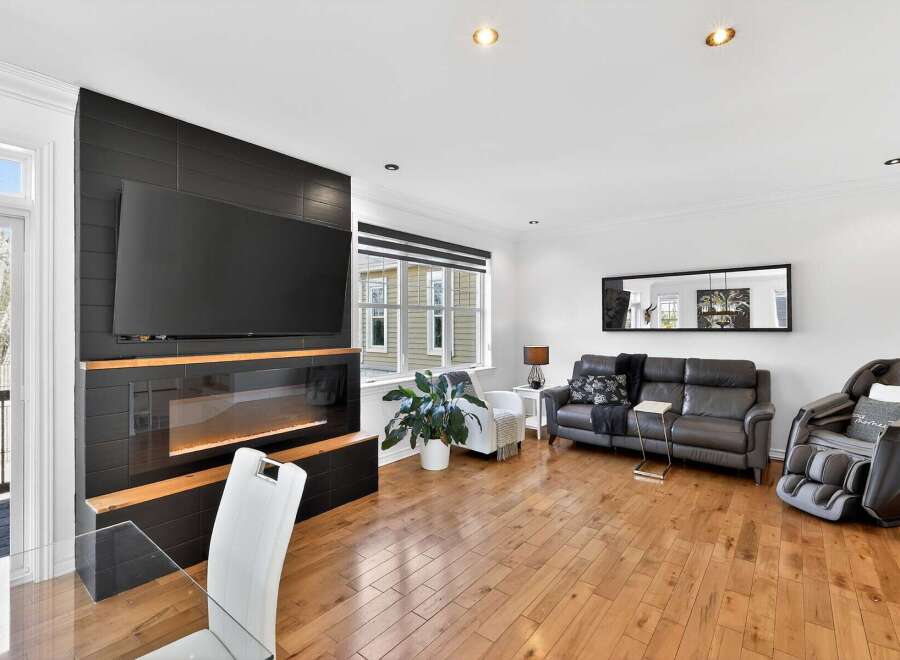 Step into luxury with this stunning living room, featuring a modern fireplace and a large flat-screen TV, perfect for cozy evenings.