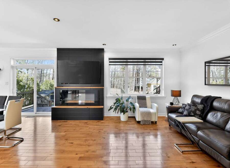 This stunning living room boasts a modern fireplace with a built-in TV, creating a cozy and stylish focal point.
