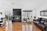 This stunning living room boasts a modern fireplace with a built-in TV, creating a cozy and stylish focal point.