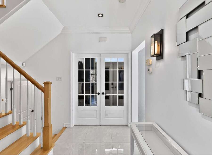 Step into elegance with this stunning entryway, featuring a grand staircase and beautiful double doors.