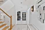 Step into elegance with this stunning entryway, featuring a grand staircase and beautiful double doors.