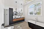 Step into luxury with this stunning bathroom! Featuring a sleek, modern design, this space boasts a double vanity with stylish round mirrors and pendant lighting.