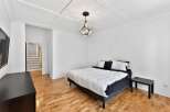 This stunning bedroom boasts a modern design with a geometric pendant light and a coffered ceiling, creating a sophisticated ambiance.