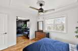 Discover the charm of this inviting bedroom, featuring a stylish ceiling fan and a well-appointed dresser.