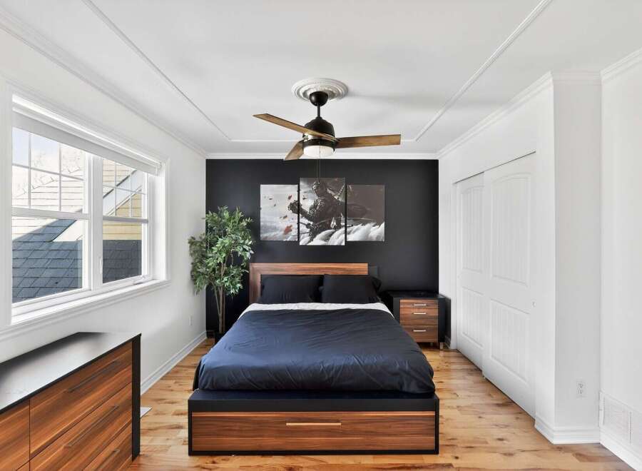 This stunning bedroom boasts a modern design with a dark accent wall, creating a sophisticated ambiance.