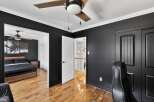 Step into this stylish bedroom featuring a modern design with sleek black walls and elegant white trim.