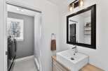 This stunning bathroom boasts a modern design with a sleek, white rectangular sink and a stylish black-framed mirror.