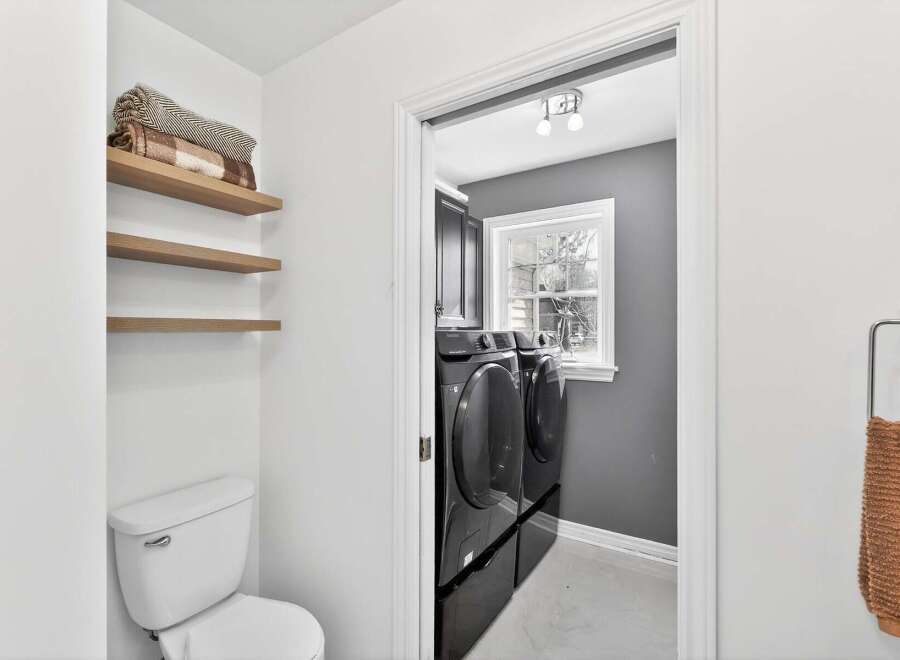 Step into this beautifully designed laundry room, featuring modern appliances and ample storage.
