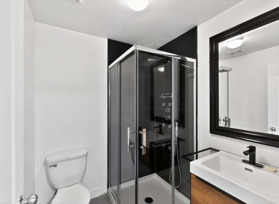 Step into this modern bathroom featuring a sleek glass shower enclosure and contemporary fixtures.