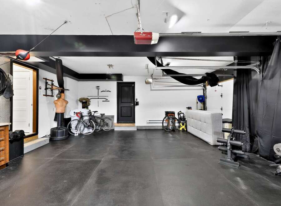 This spacious garage has been transformed into a versatile home gym and storage space.