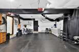 This spacious garage has been transformed into a versatile home gym and storage space.