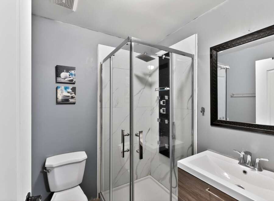 Step into a modern bathroom oasis! This space features a sleek glass-enclosed shower with a rainfall showerhead, perfect for a spa-like experience.