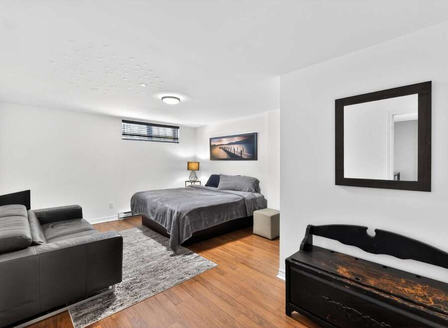 This cozy bedroom offers a serene retreat with its modern design and ample natural light.