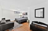 This cozy bedroom offers a serene retreat with its modern design and ample natural light.
