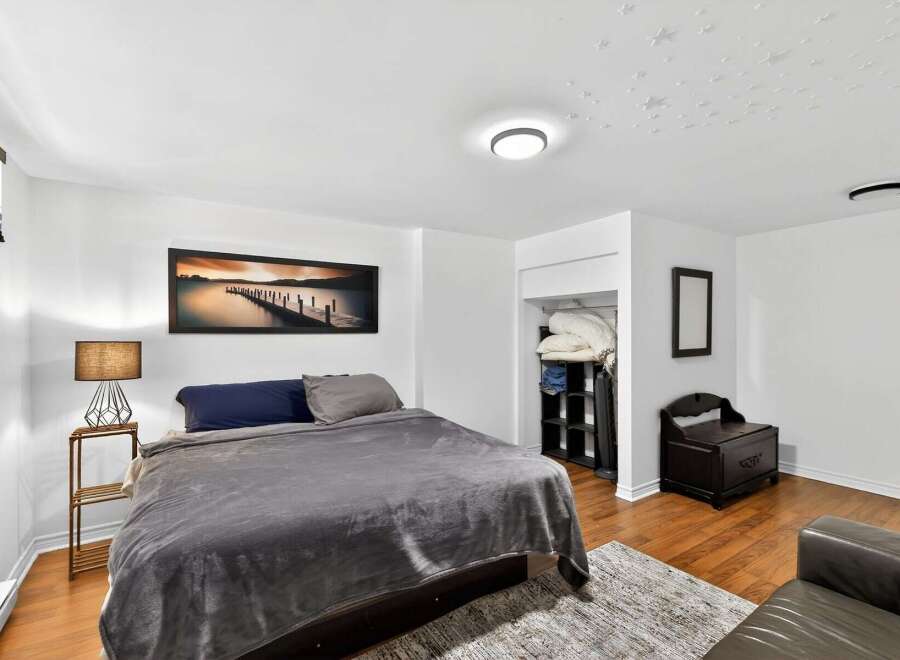 Discover the charm of this inviting bedroom, featuring a cozy bed and a stylish lamp.