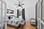 Step into this inviting bedroom, featuring a comfortable bed with stylish bedding and a cozy seating area.