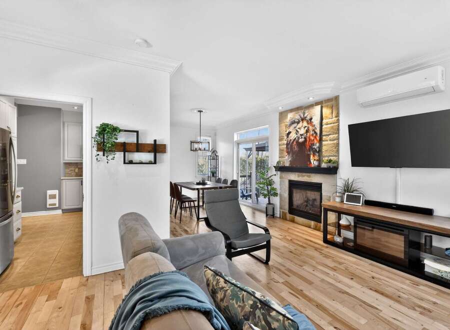 Step into luxury with this stunning property, featuring a modern living room with a cozy fireplace and a large flat-screen TV.