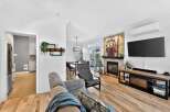Step into luxury with this stunning property, featuring a modern living room with a cozy fireplace and a large flat-screen TV.