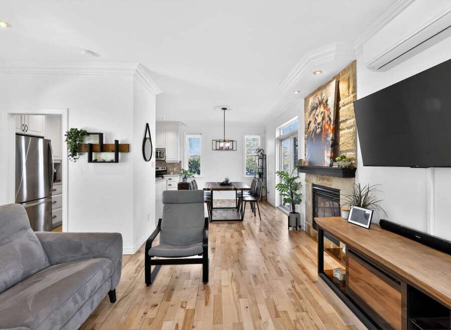 Step into luxury with this stunning property! Featuring a modern living space with hardwood floors, a cozy fireplace, and a sleek entertainment center.