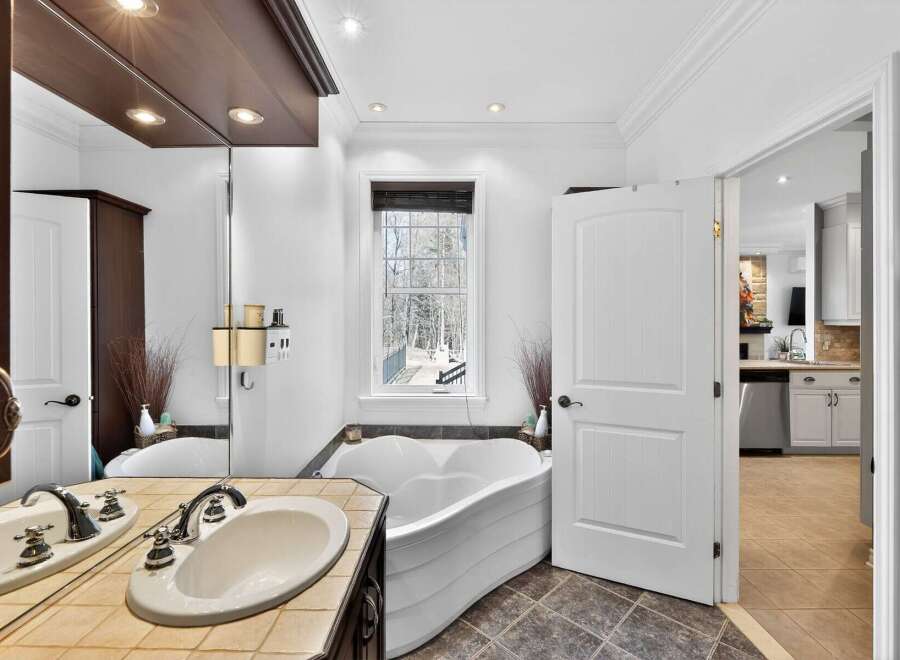 Step into luxury with this stunning bathroom featuring a unique, heart-shaped tub and a stylish vanity.