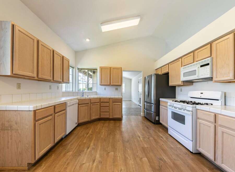 Step into this inviting kitchen, featuring ample cabinet space and modern appliances.