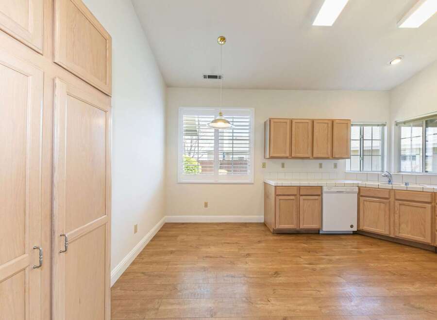 Step into this inviting kitchen, featuring ample cabinet space and a bright, airy atmosphere.