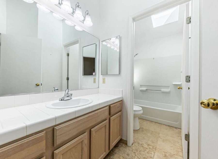This bathroom features a bright and airy design with a large vanity and ample counter space.